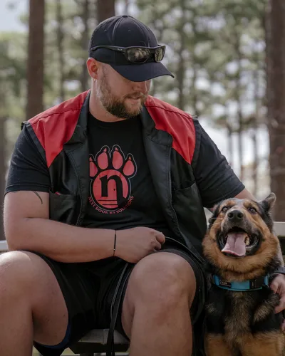 Zack Barkley seated with a German Shepherd