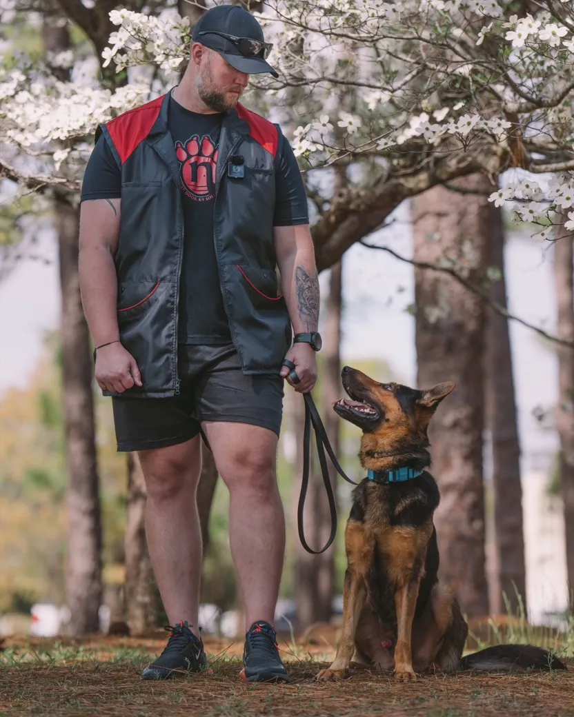 Zack Barkley standing with a German Shepherd on a loose leash